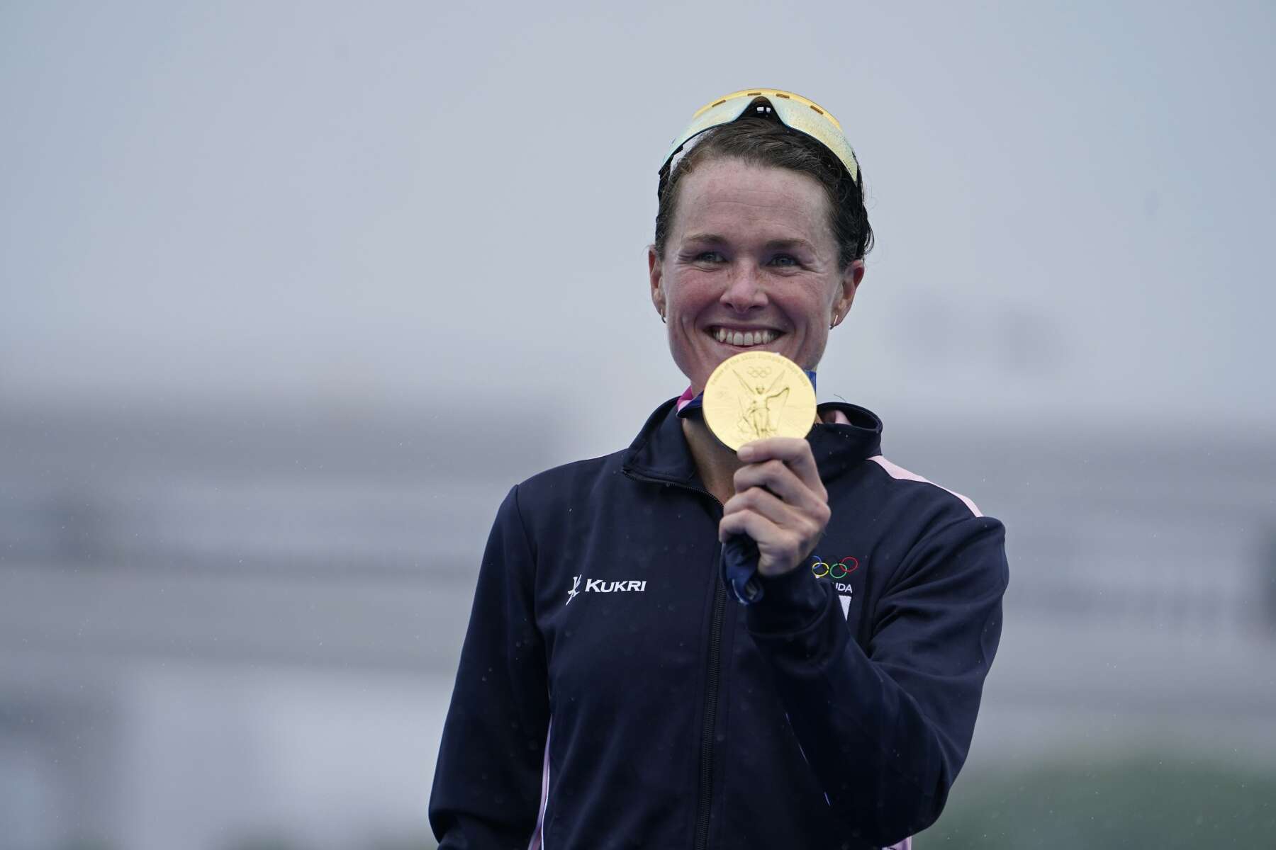 Dame Flora Duffy holding her Olympic gold medal
